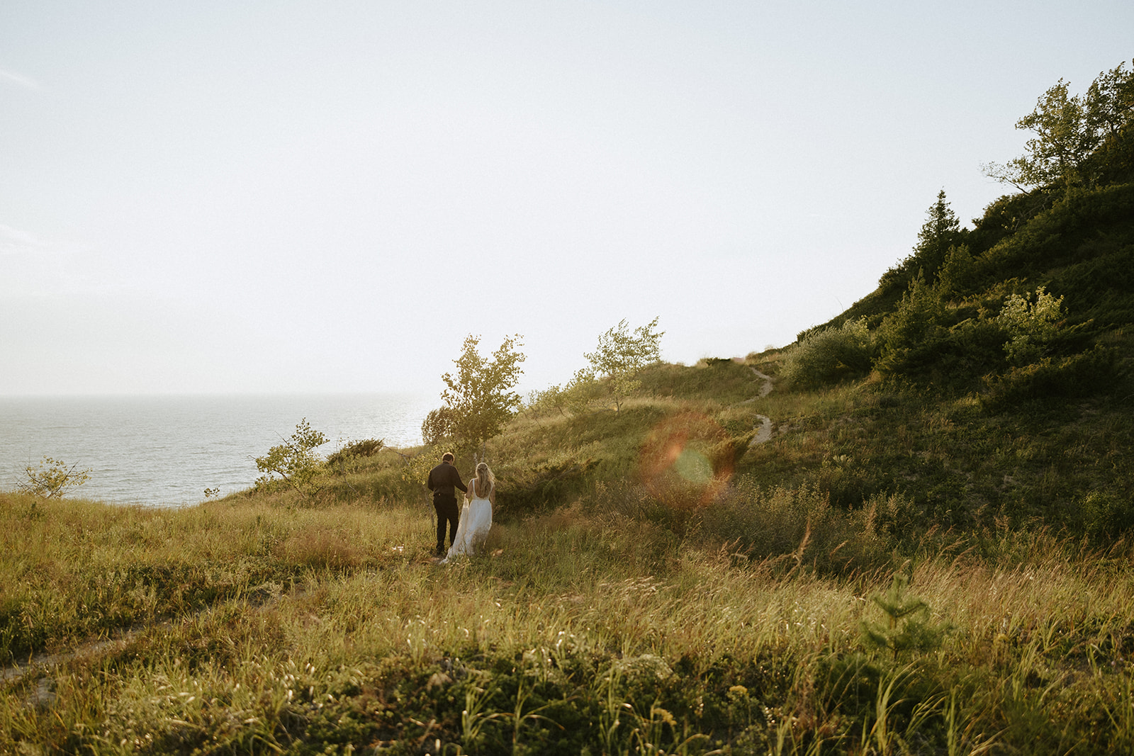 Sunset photos of a bride and groom at Lake Bluff Preserve in Frankfort, Michigan